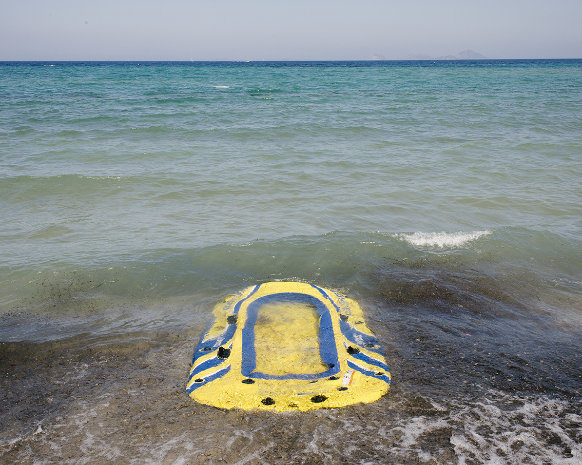 Tourists vs. Refugees; Zurückgelassenes Schlauchboot von Flüchtlingen am Strand, August 2015, Kos, Insel Kos, Griechenland, Europa, © Joerg Brueggemann/OSTKREUZ